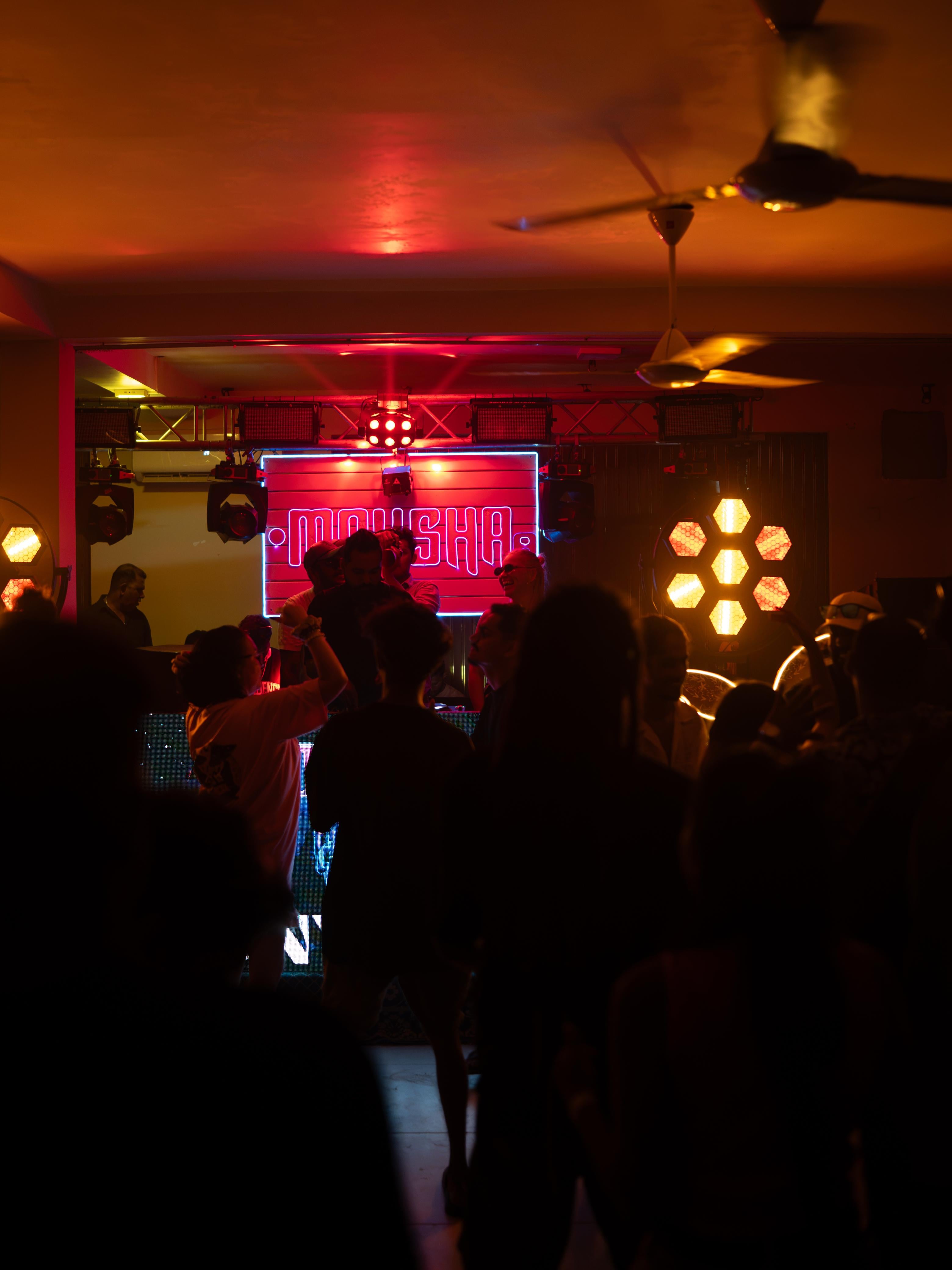 Dance floor silhouettes under Mokshaa stage lighting